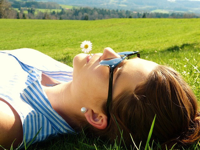 young woman lying on the grass - how to reduce cortisol - diagnost